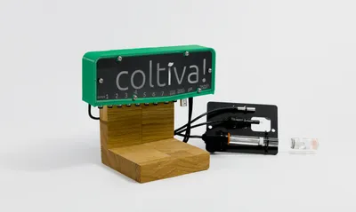 The Coltiva control unit mounted on an oak stand, connected to a pH sensor and dosing line.